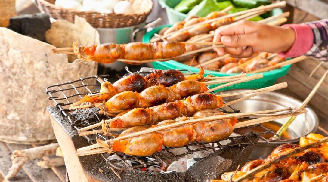 Closeup image of a street food vendor cooking meat and fish