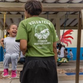 Volunteer and young girl play outside on a childcare project in Ecuador.