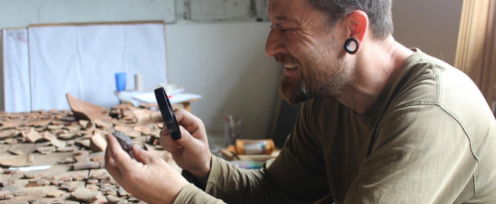 An archaeologist closely examines an artefact during one of our Archaeology opportunities abroad in Peru.
