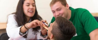 Des stagiaires examinent un patient pendant une campagne de soins sur l'un de nos projets médicaux à l'étranger. 