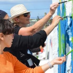 Childcare volunteers paint a mural