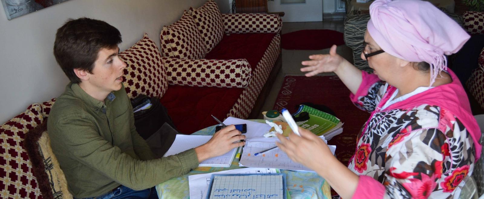 Projects Abroad volunteer goes through his Arabic homework given to him during the language lessons.