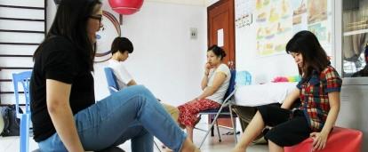 A female intern is pictured gaining physiotherapy work experience whilst assisting locals affected by Agent Orange during her physiotherapy internship in Vietnam.