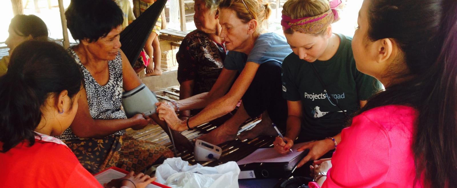 Interns learn how to take people’s blood pressure readings as part of Public Health work for teenagers in Cambodia. 