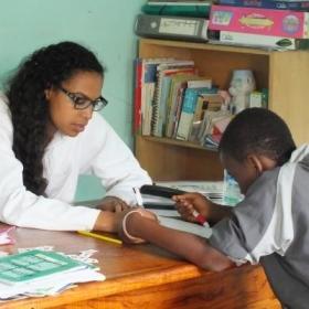 A local child is treated by a student doing a Speech Therapy internship abroad in Africa.