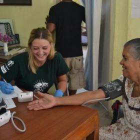 During outreach work in Sri Lanka, a public health intern takes a woman’s blood pressure reading.