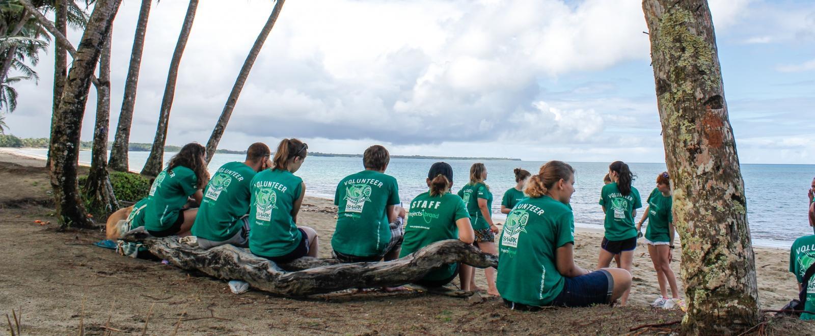 Projects Abroad volunteers in Fiji take a break after a beach clean-up.