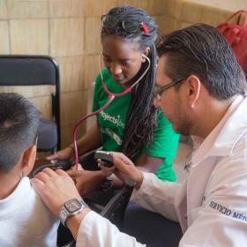 Medical interns in Mexico help at an outreach alongside a local doctor. 