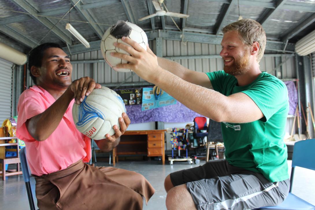 A physiotherapy volunteer uses a soccer ball as part of a therapy session on an ethical volunteering opportunity abroad. 