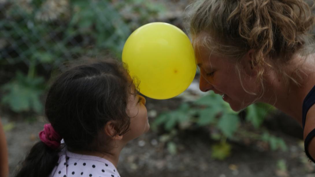 On a spring break community service trip in Costa Rica, a student and child play an Early Childhood Development game using a balloon. 