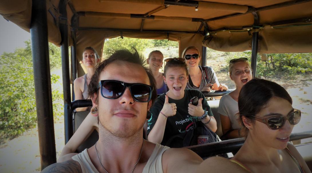 En grupp ungdomsvolontärer åker safarijeep i bushen i Botswana.