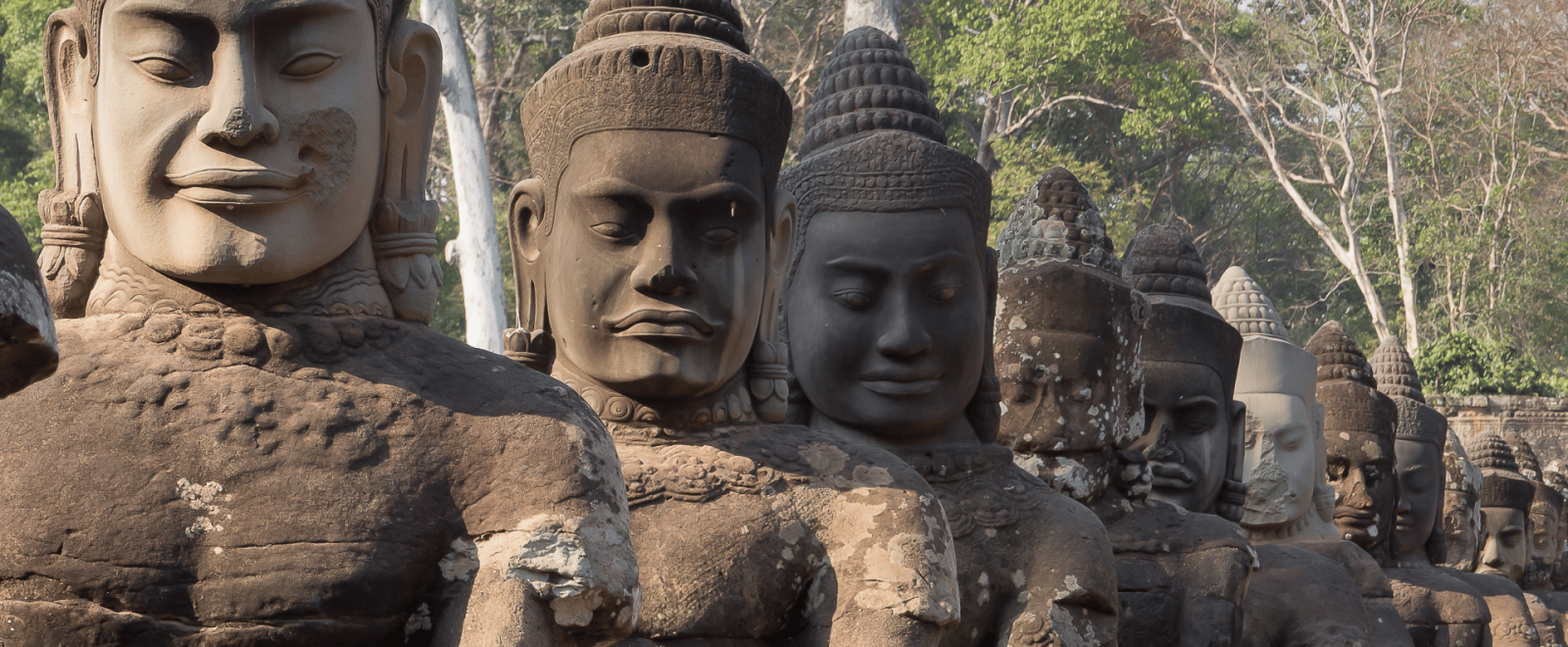 A line of stone carvings depicting humans at Angkor Wat
