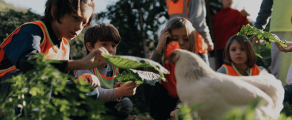 Children in a garden with a chicken in the foreground